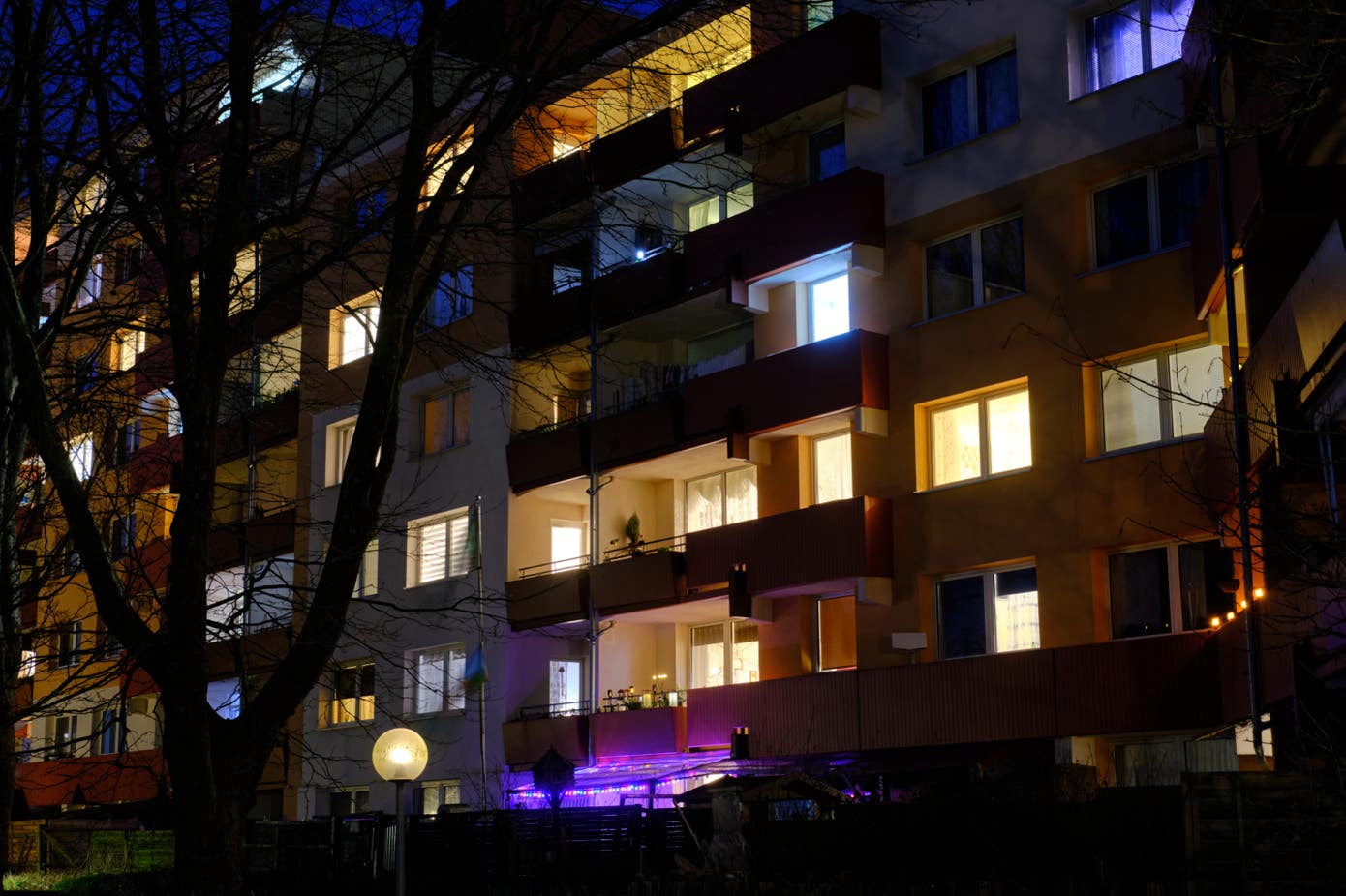 Wohnfassade in Kinderhaus in der Dunkelheit mit beleuchteten Fenster